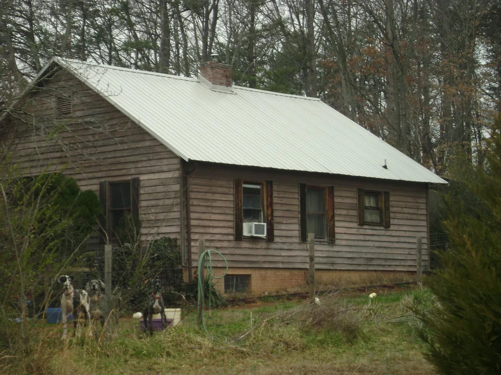 White metal roof on an old wood sided farmhouse, from a Metal Roof Installation job in Roberts